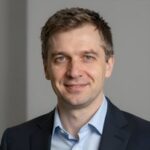 Портрет уверенного российского бизнесмена в студийном освещении на нейтральном фоне для компании Maxra